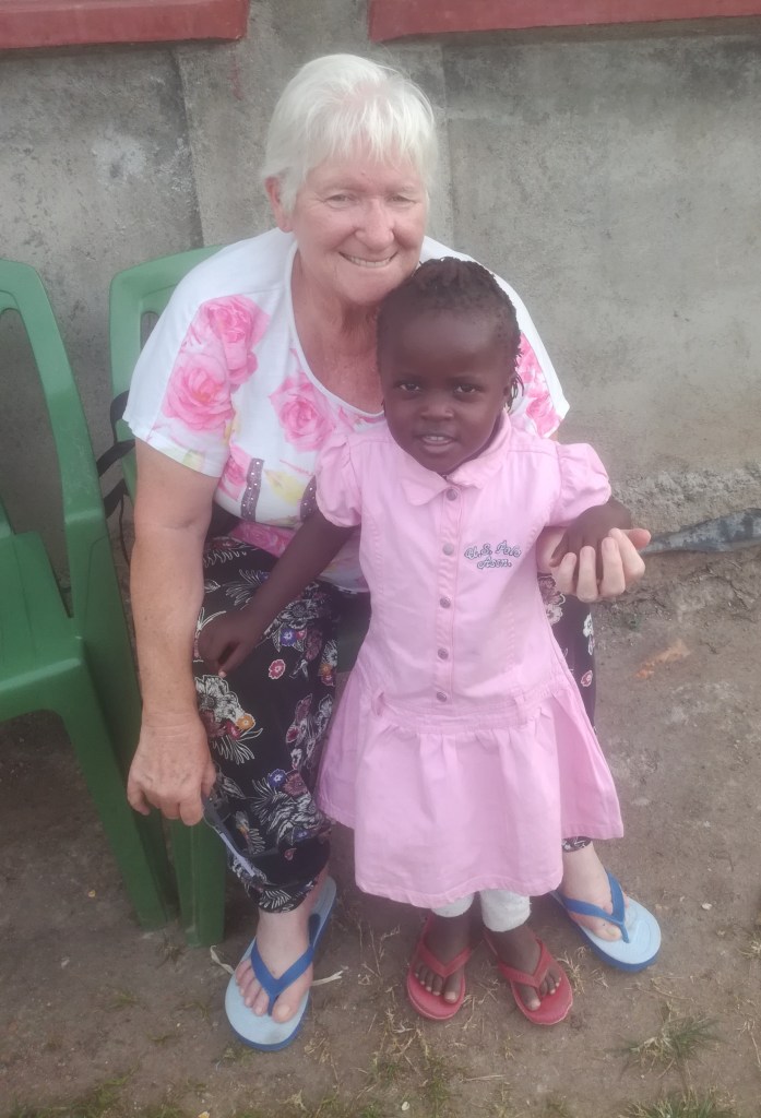 Sylvia with Kenya girl in pink dress